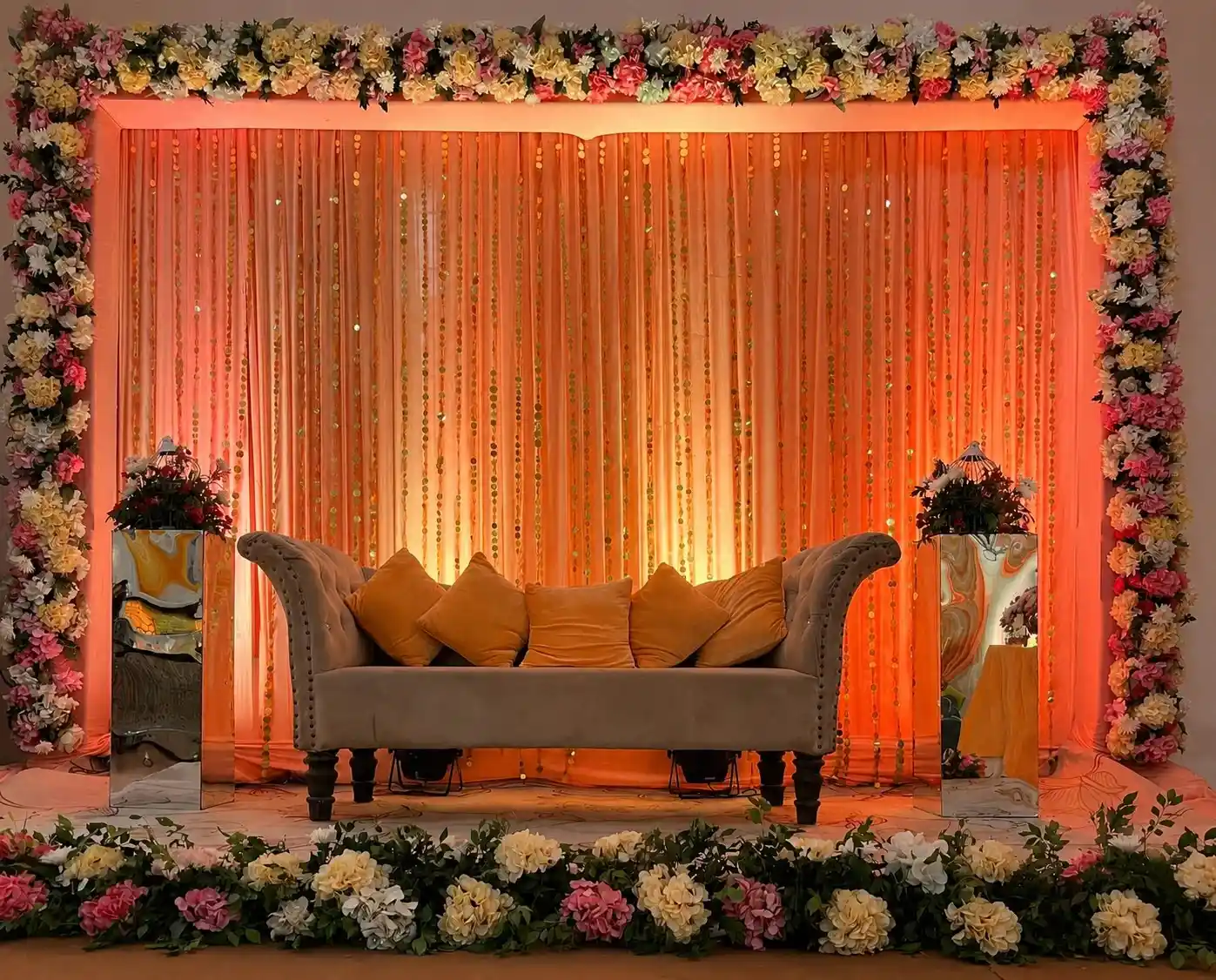 Modern wedding stage decoration with LED backdrop, elegant flowers, and luxury seating arrangement.